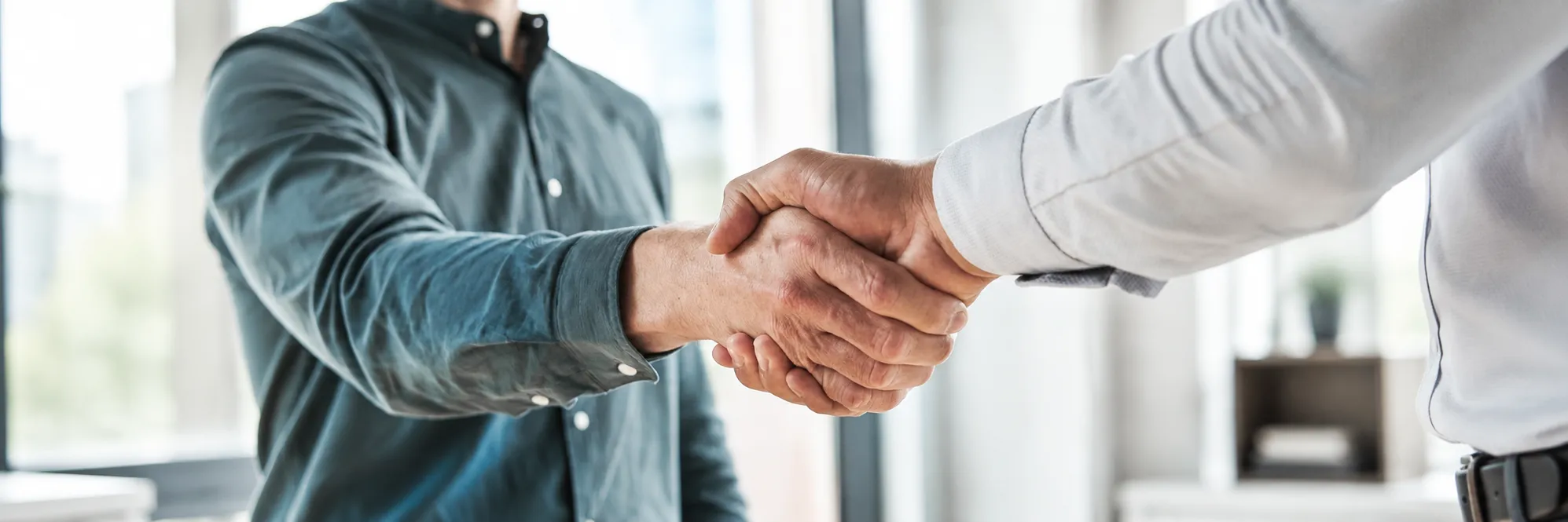 Handschlag zwischen zwei Personen als Symbol für partnerschaftliche Zusammenarbeit