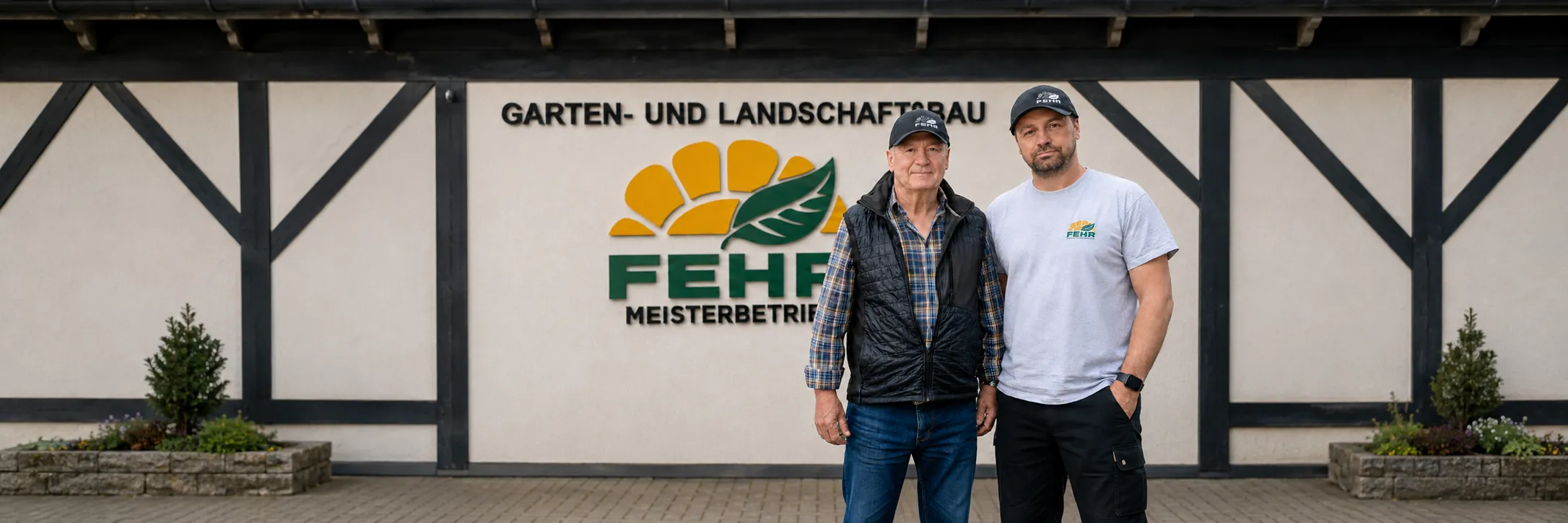 Marcel Fehr mit seinem Vater vor dem Firmenschild von Fehr Garten- und Landschaftsbau in Oberstdorf